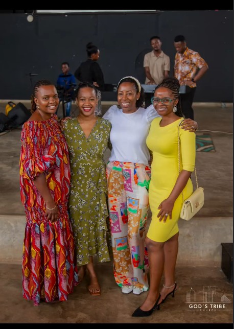 Four women from God’s Tribe smiling together in the hall after service